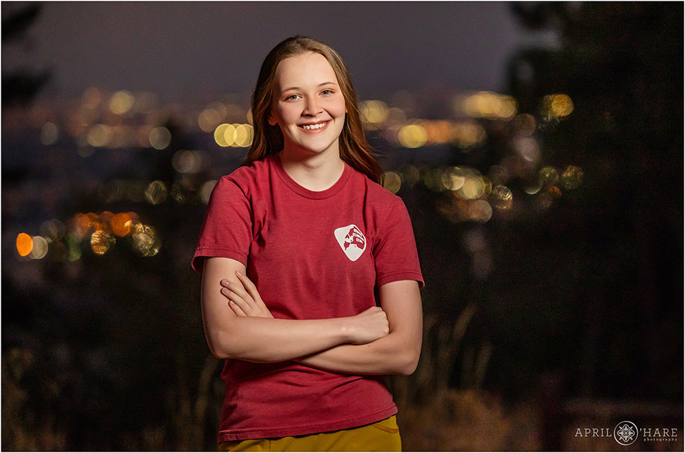 Night photo with pretty city lights in the backdrop for a senior session on Lookout Mountain in Golden Colorado