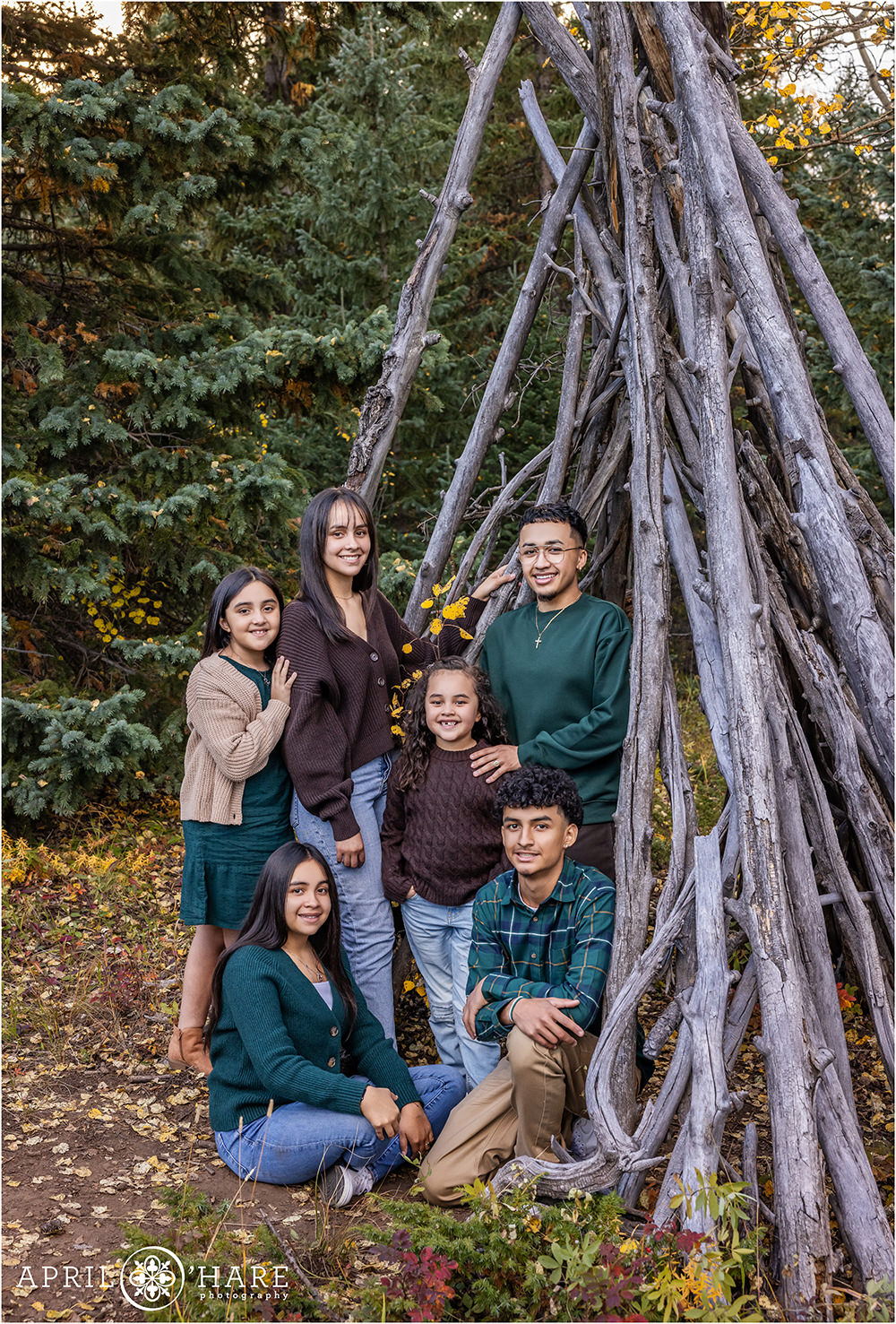 Six kids pose for a photo together in the woods of Colorado during autumn