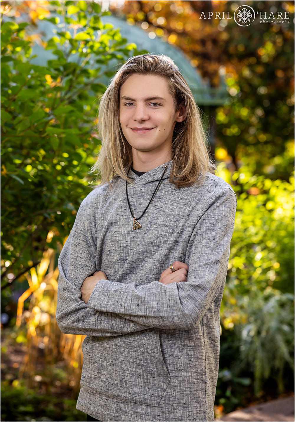 Fall Color Senior Portrait with the Green Iron Greenhouse Solarium in the backdrop at Denver Botanic Gardens