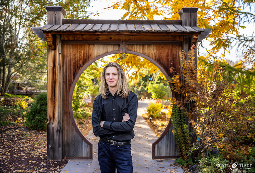 Japanese wood circle passageway in the backdrop for a senior photo at Denver Botanic Gardens