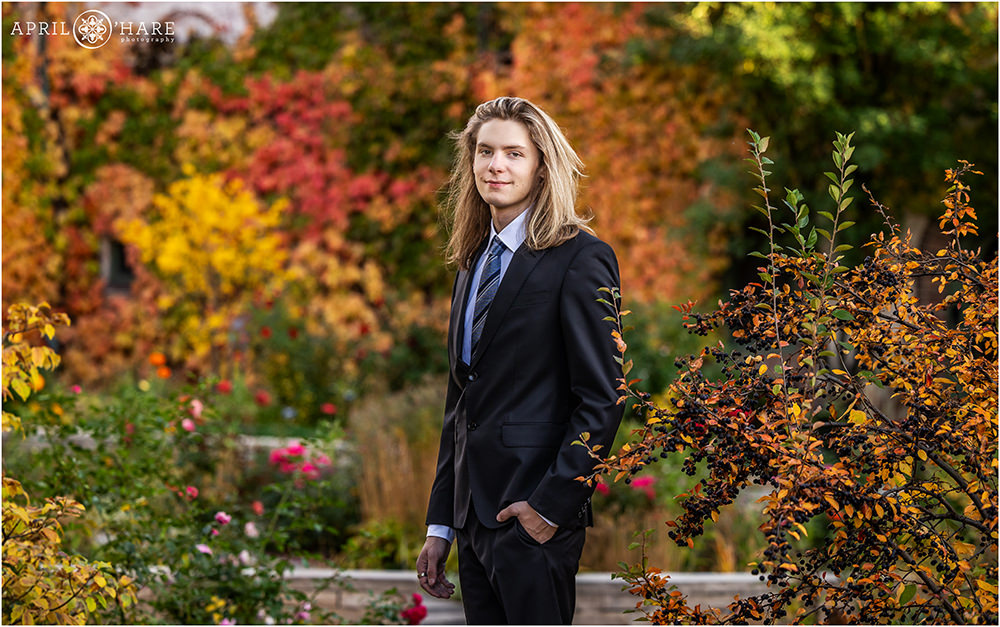 Beautiful fall color backdrop for senior boy wearing a suit at Denver Botanic Gardens in Colorado