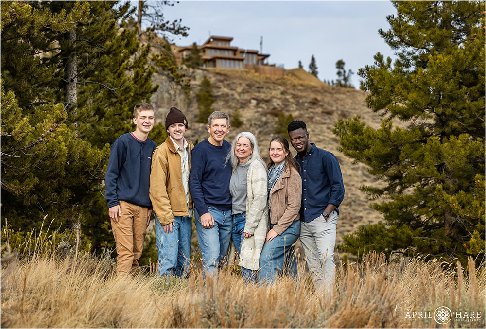 Family portrait with their new house in the backdrop in Grand County Colorado