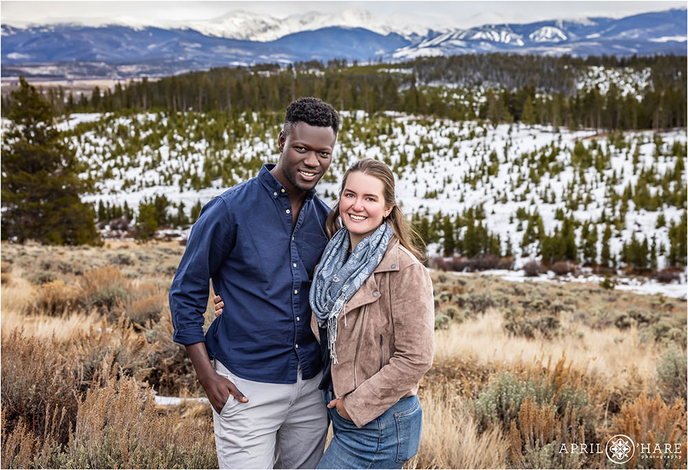 Beautiful couples portrait during winter with a pretty snowy mountain landscape in the backdrop near Winter Park Colorado