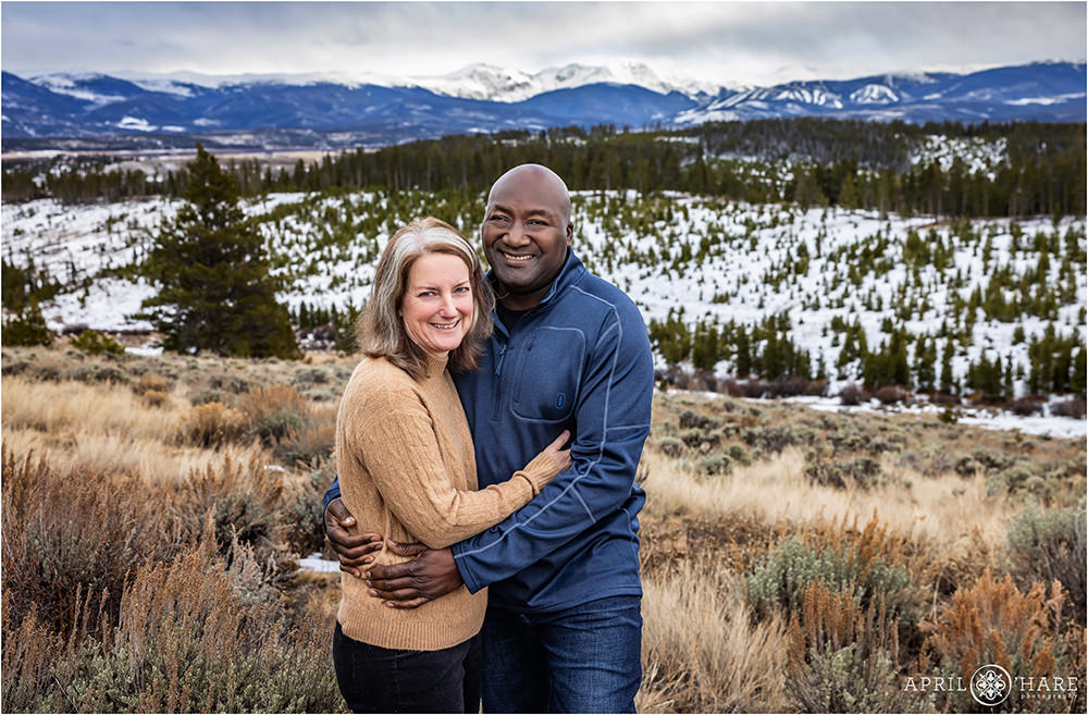 Cute Couples portrait with a snowy winter backdrop of snow covered mountains in Grand County, Colorado