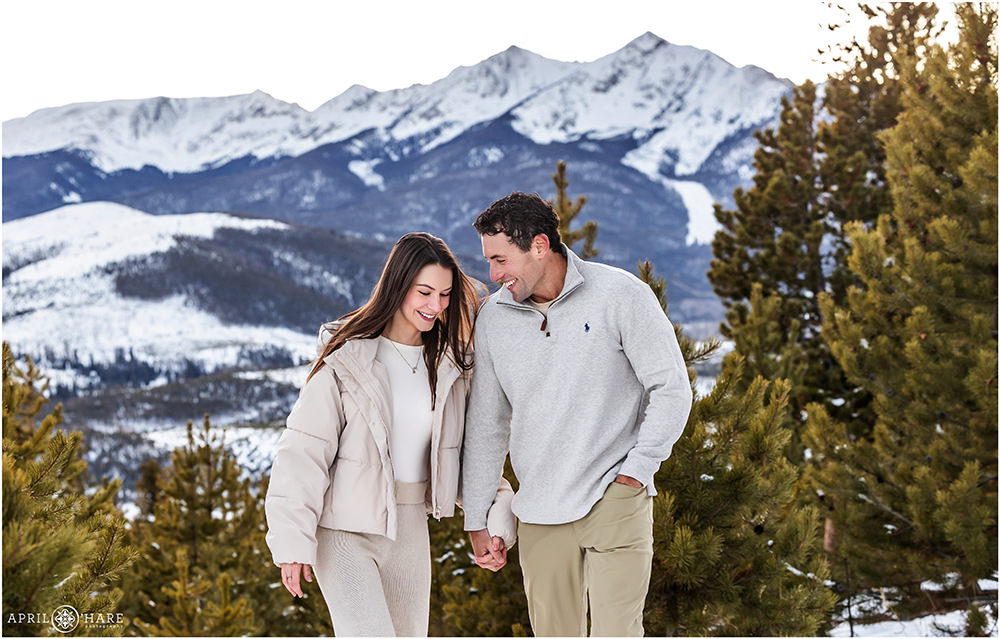 Couple walk hand in hand with a pretty snowy backdrop at Sapphire Point in Colorado