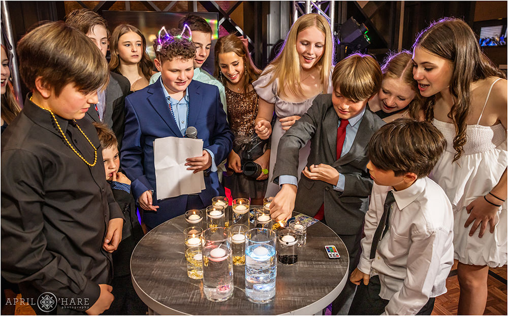 Kids gather around to light the birthday candles at their friend's bar mitzvah party in Denver CO