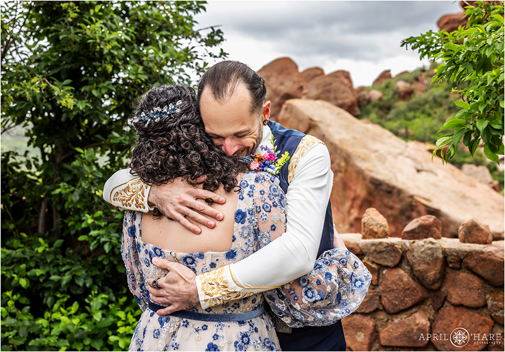 Groom hugs his bride during their first look at Red Rocks