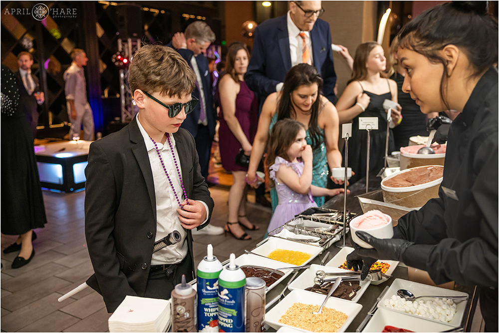 Kid gets ice cream from the ice cream bar at a Bar Mitzvah party in Denver