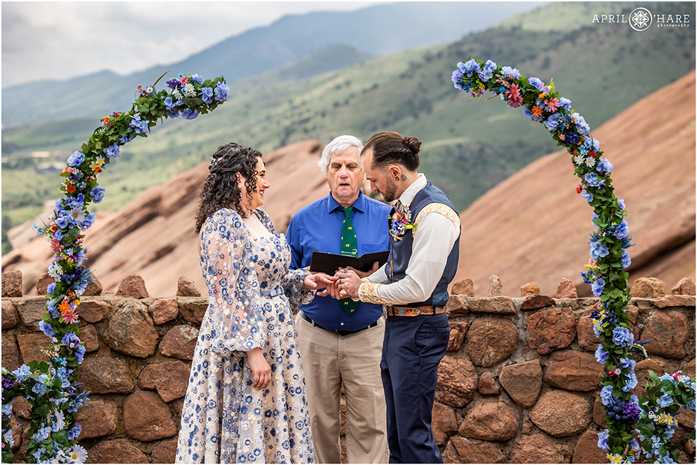 Couple exchange rings during their ceremony at Red Rocks