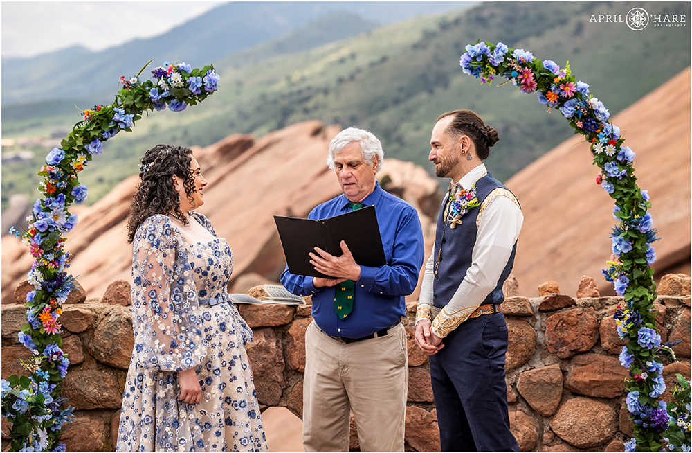 Couple smile at each other durng their outdoor wedding at the Red Rocks Trading Post Backyard ceremony in CO
