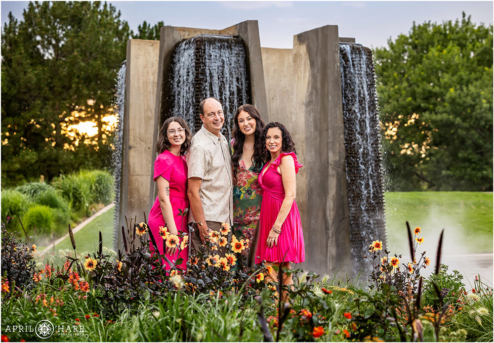 Family of four wearing bright pink is photographed in front of the Four Towers Pool at Denver Botanic Gardens