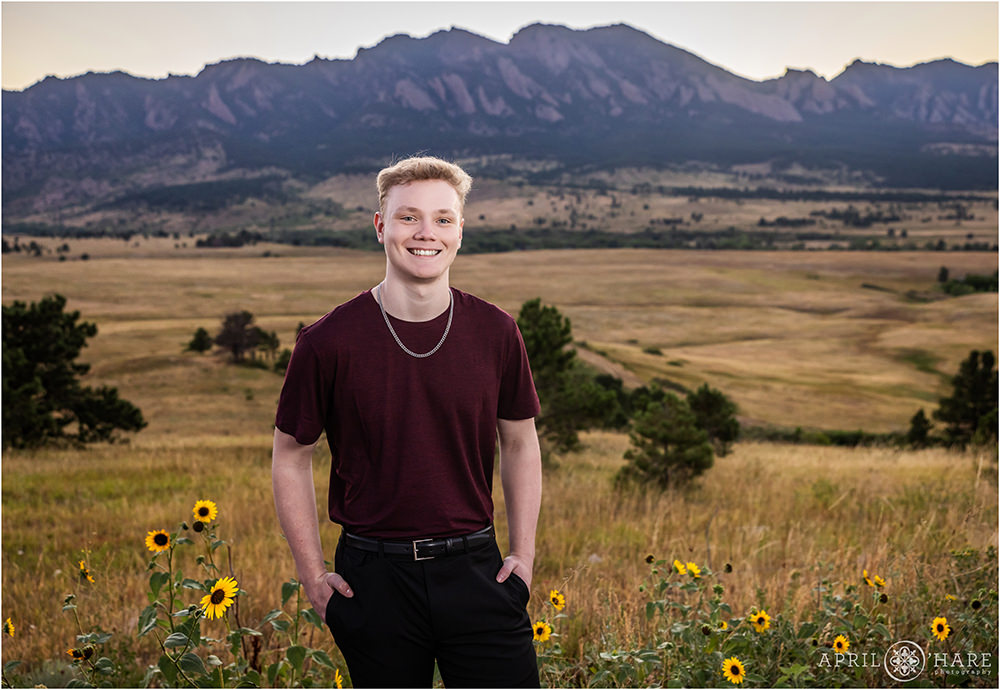 Senior photo with sunflowers and beautiful mountain backdrop in Boulder Colorado