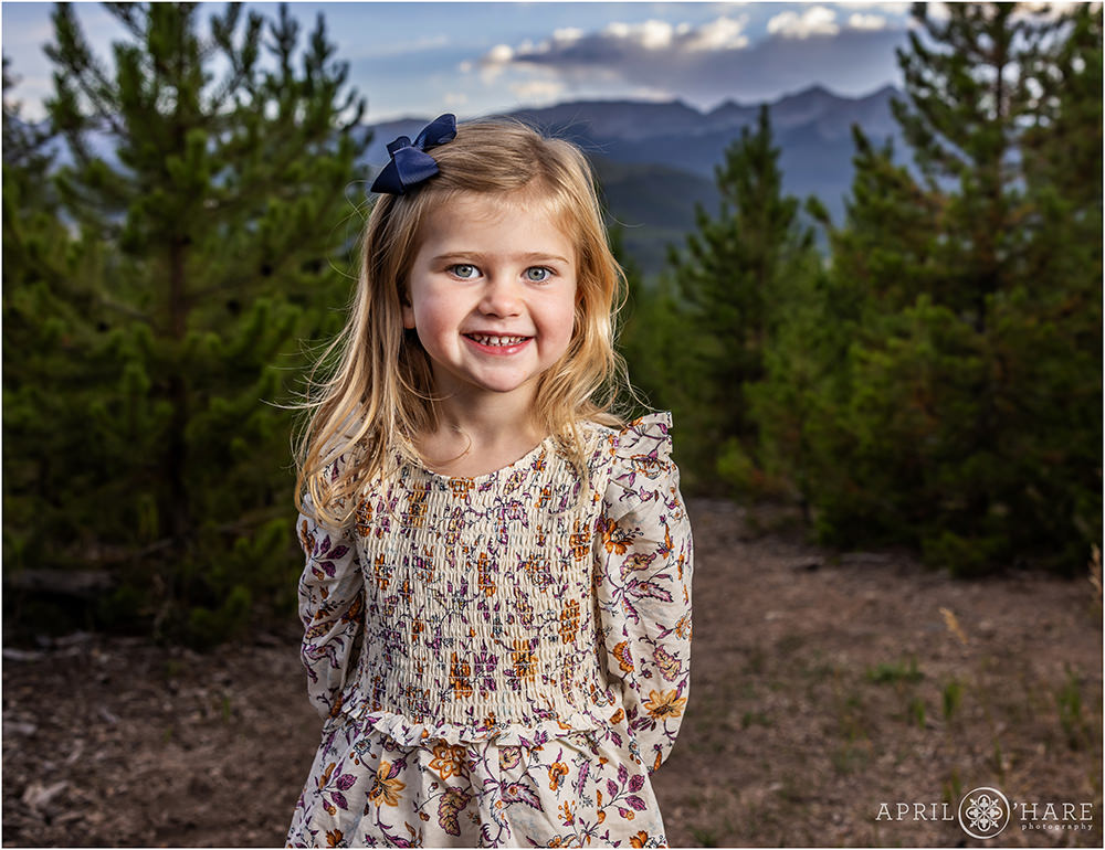 Adorable girl wearing a floral dress gets her own individual photo at her family photoshoot at Sapphire Point in Colorado