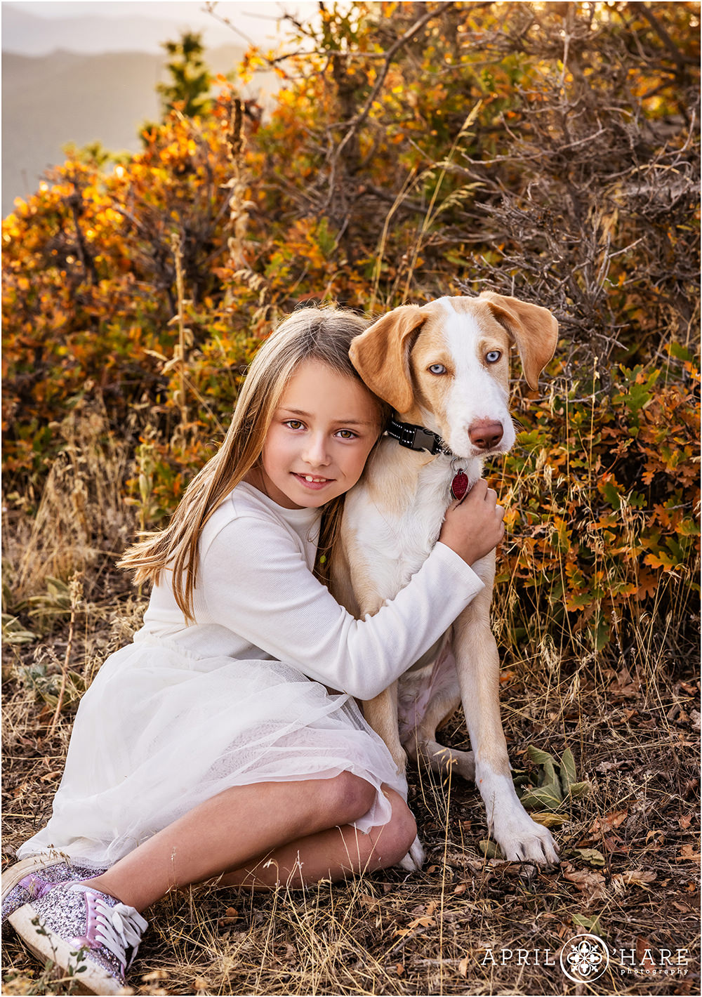 Fall color photo of a young girl with her puppy at West Mount Falcon