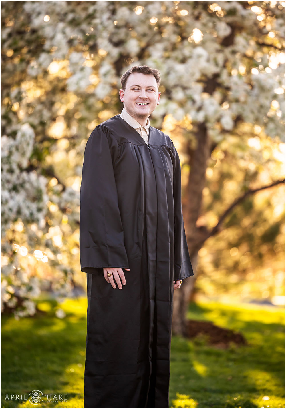 Graduation portrait with big spring blossoms in the backdrop at City Park in Denver Colorado