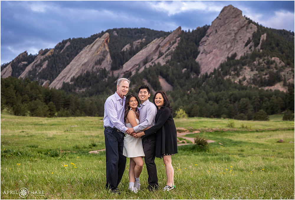 Family of four get a flatiron mountain backdrop photo at Chautauqua at their son's graduation photoshoot in Boulder CO