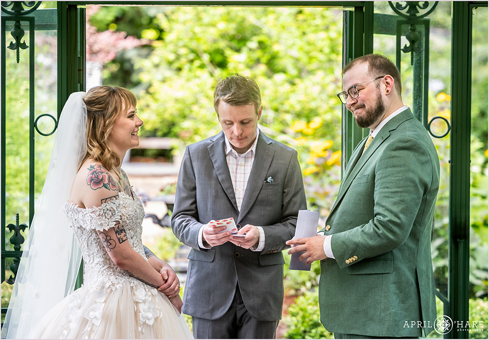 Cute moment during a wedding ceremony at the Woodland Mosaic Solarium during June at Denver Botanic Gardens