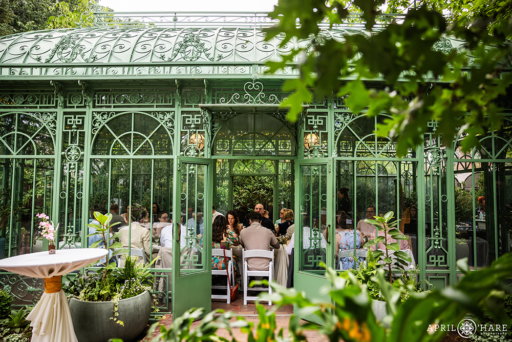 Wedding guests enjoy dinner at the Denver Botanic Gardens Woodland Mosaic Solarium