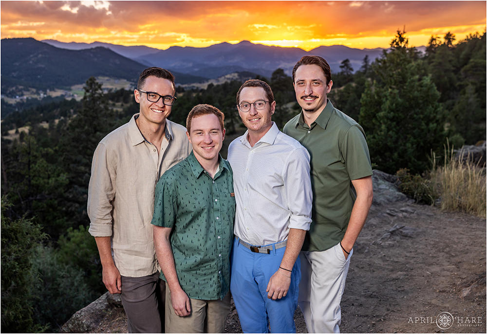 Four adult cousins pose together in front of the sunset mountain backdrop at West Mount Falcon