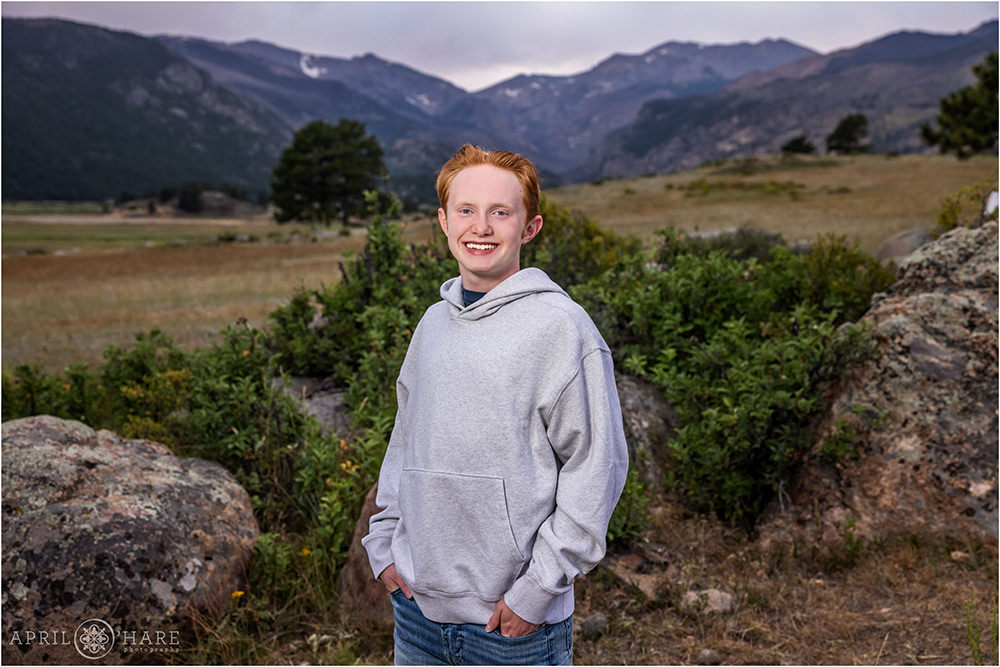 Senior boy wearing a gray hoodie at RMNP during August