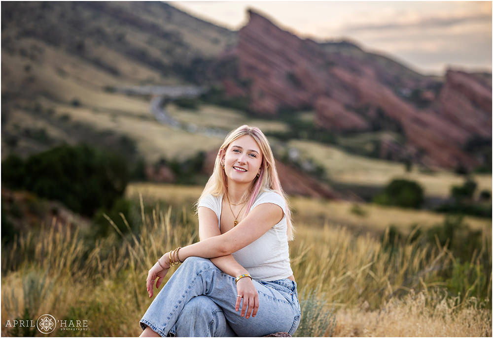 Senior photo with red rocks backdrop taken during mid August at the Morrison Trailhead