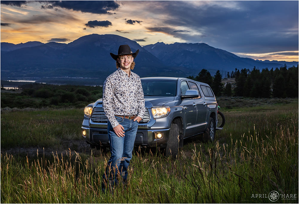 Senior boy poses with his truck at sunset in the mountains of Colorado
