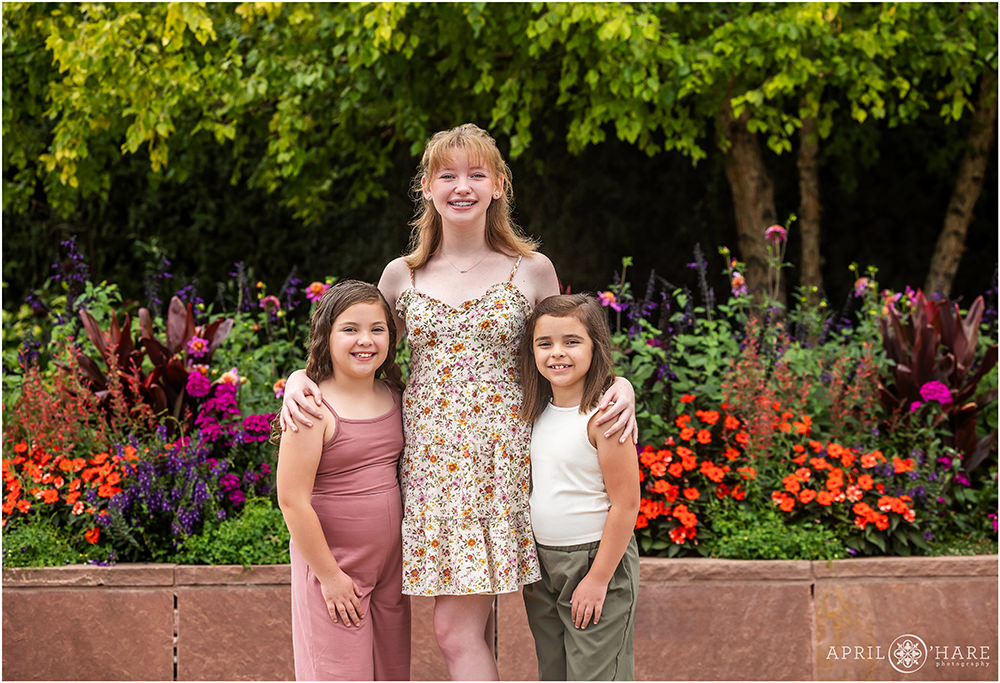 Three sisters stand in front of a colorful garden at Denver Botanic Gardens