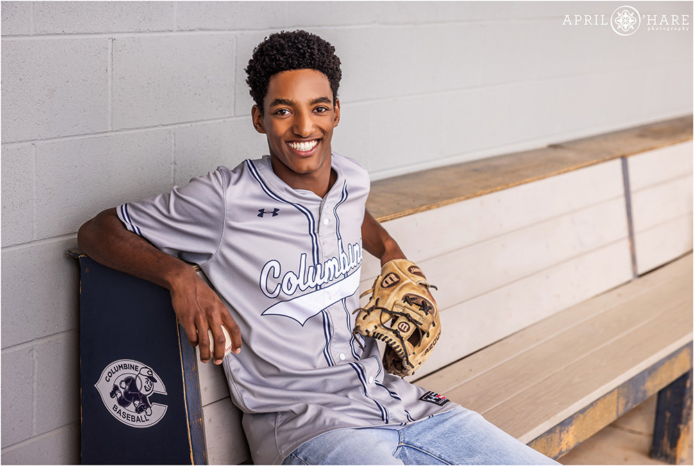 Baseball loving senior hangs in the dugout at Columbine High School baseball field in Littleton CO