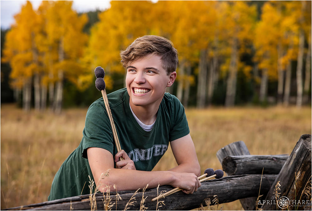 Drummer gets his senior photos done in the fall color of Evergreen CO