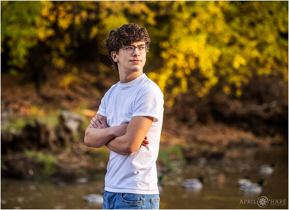 High school senior portrait for a boy with ducks swimming in the backdrop in Colorado