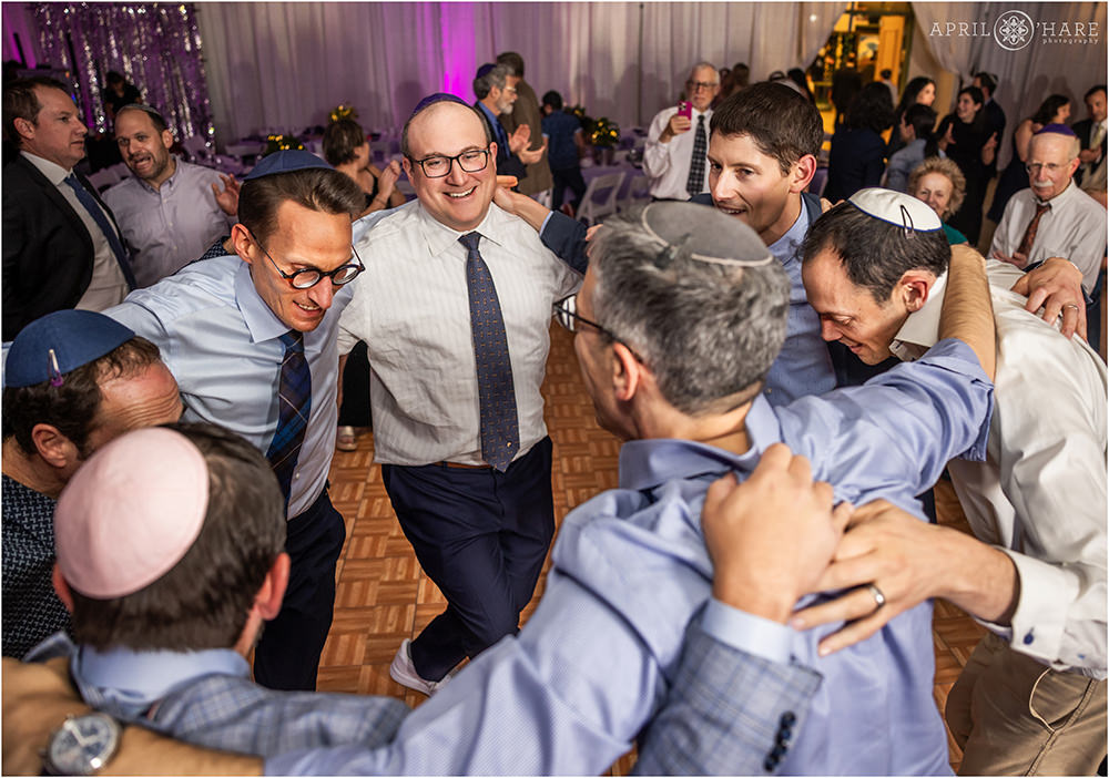 A father dances in a circle with his buddies at his daughter's bat mitzvah party in Denver at the Hebrew Educational Alliance