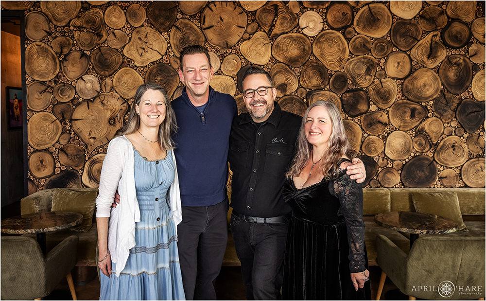 Friends pose for a photo together in front of the wood wall at Stellar Jays for a birthday brunch party in Denver CO