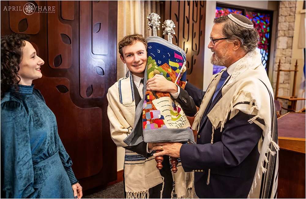 Bar Mitzvah boy holds the Torah at his rehearsal at Temple Sinai
