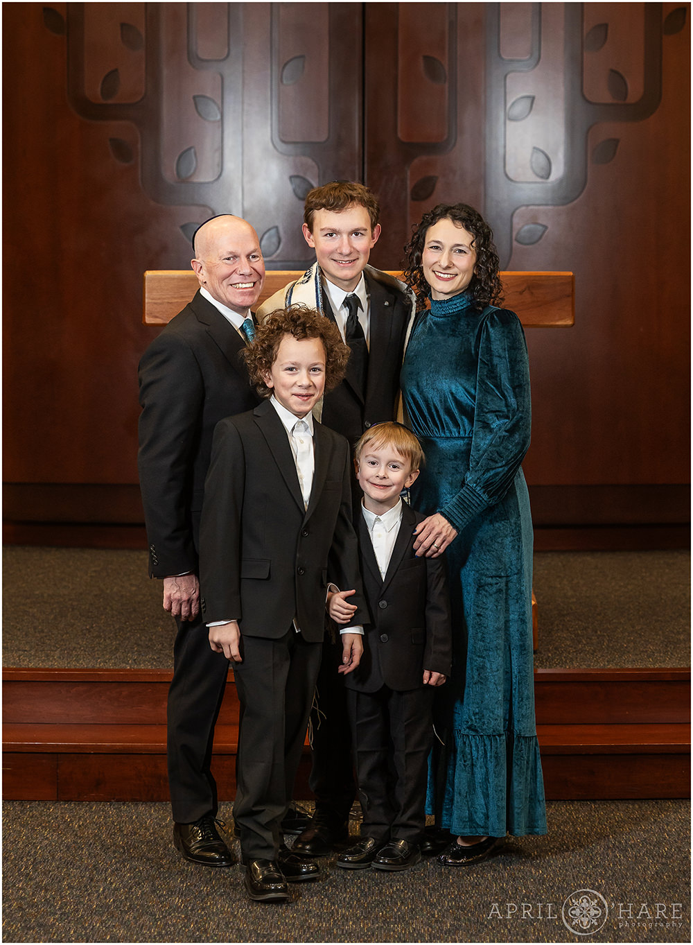 A family of five with three boys pose for a nice classic family portrait at their oldest son's bar mitzvah rehearsal at Temple Sinai in Denver CO