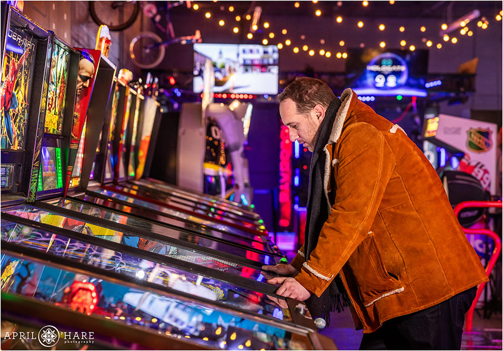A man plays pinball at a bar mitzvah party at Super Awesome Fun Factory in Denver CO