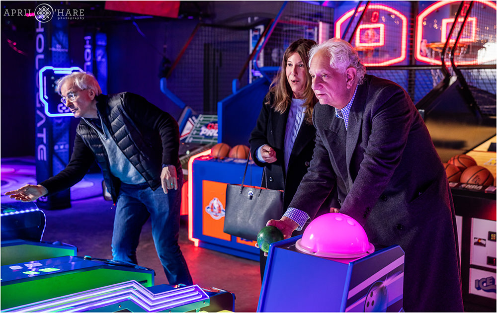 Family play skee ball together at a young man's bar mitzvah party in Denver CO