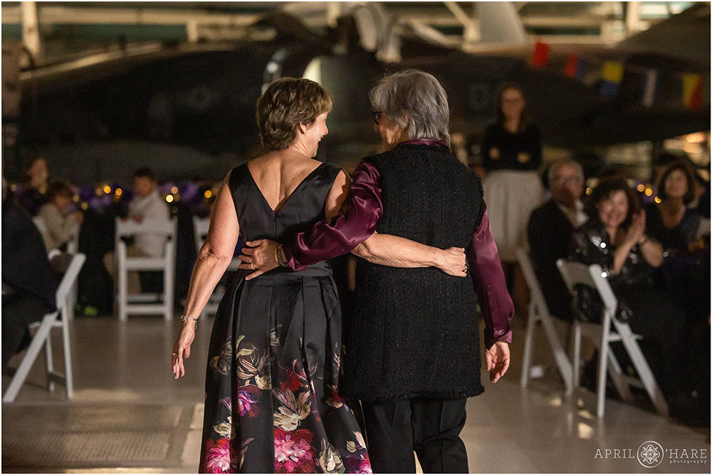 Two grandmas walk arm in arm after a prayer for their grandson at his bar mitzvah party in Denver CO