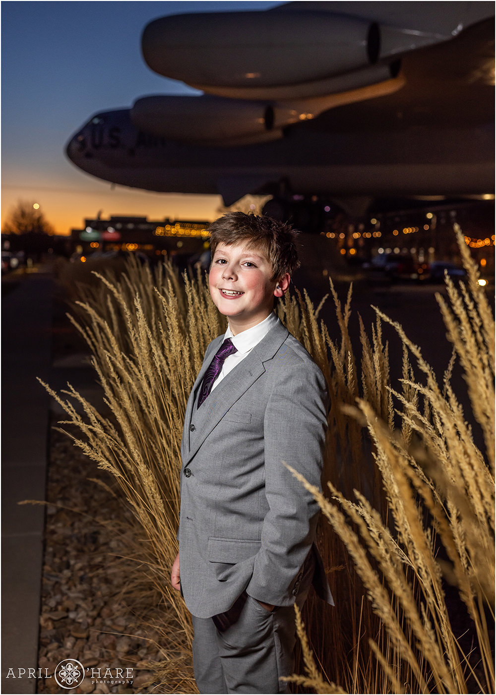 Young man poses in front of a large airplane at sunset at Wings over the Rockies in Denver, CO