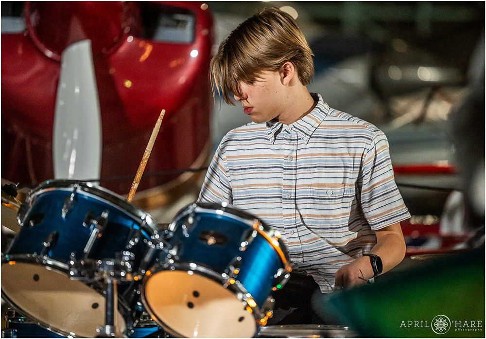 A young man plays the drums during his rock band's set at a bar mitzvah party at Wings over the Rockies