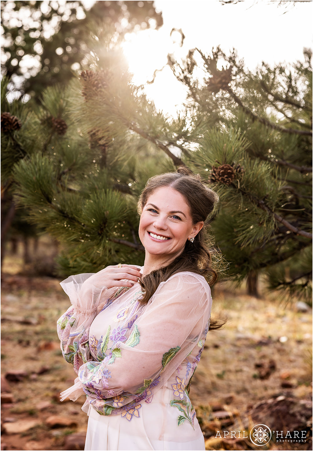 Pretty evergreen tree backdrop with pine cones for a natural headshot portrait at Shanahan Ridge in Boulder, CO