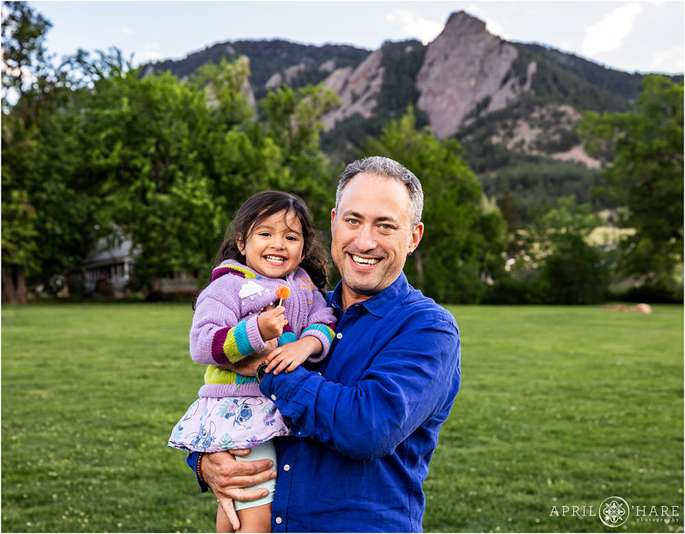 Mountain flatirons backdrop of a dad with his young daughter at Chautauqua in Boulder CO