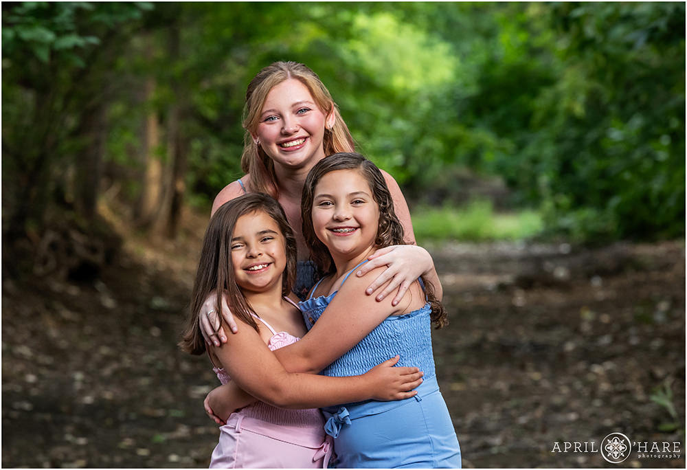 Family Sisters Photo in front of Tree Backdrop at Bible Park in Denver, CO
